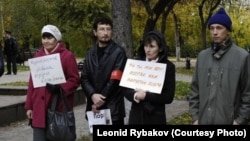 Леонид Рыбаков (второй слева) на митинге против Владимира Путина с плакатом "Пора на пенсию"