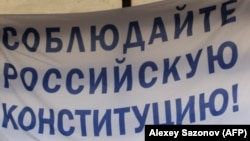 Russian human rights activist Lyudmila Alexeyeva delivers a speech with a poster on the background reading "Abide Russian constitution" during an opposition supporters rally to defend Article 31 of the Russian constitution, which guarantees the right of a