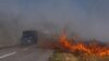 Cars drive along a burning field near Pokrovsk, Donetsk region, on September 16, 2024, amid the Russian invasion of Ukraine.