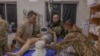 TOPSHOT - A Ukrainian wounded serviceman who was brought back from positions is being treated by Ukrainian military doctors is prepared to be transported to a hospital, at a stabilisation point of the 33rd Mechanised Brigade, near the Kurakhove town's fro